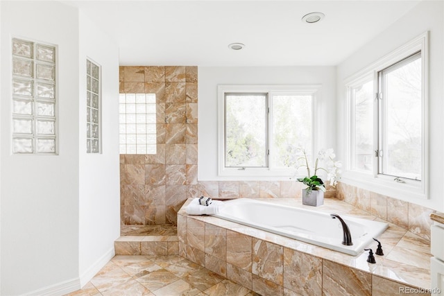 bathroom featuring baseboards, marble finish floor, a bath, and tiled shower
