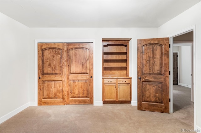 unfurnished bedroom with light colored carpet and baseboards