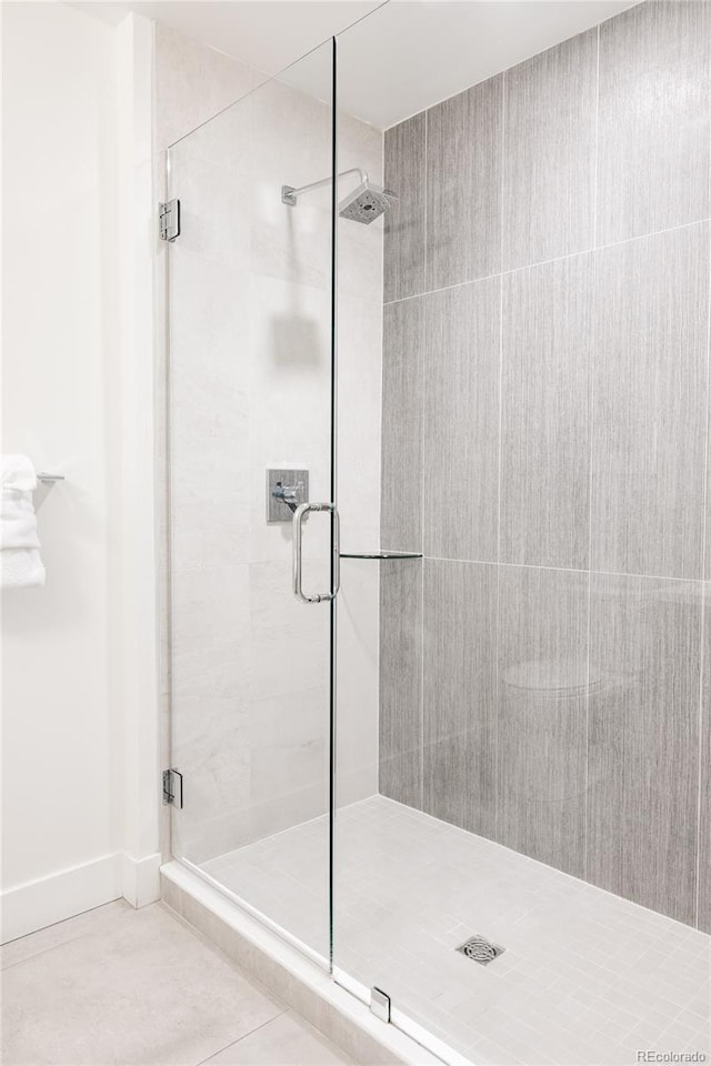 bathroom with tile patterned flooring and a shower with shower door