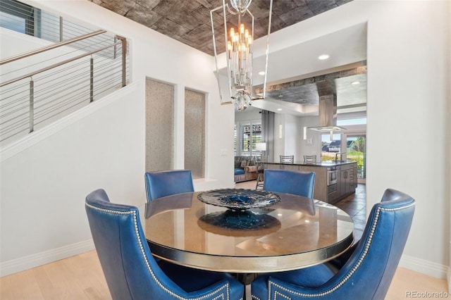 dining area featuring light wood-type flooring and an inviting chandelier