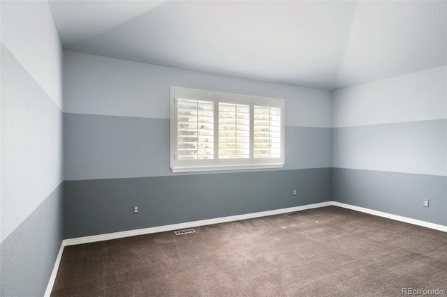 spare room featuring lofted ceiling and carpet floors