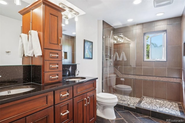 bathroom with a shower with door, vanity, and toilet