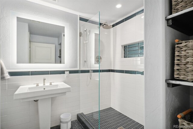 bathroom featuring tile walls, an enclosed shower, and tasteful backsplash