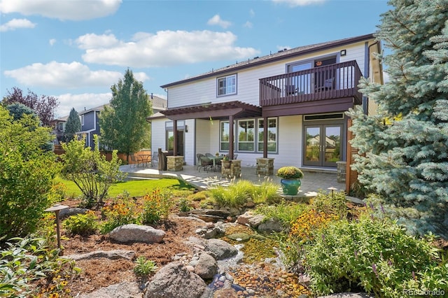 rear view of property featuring a balcony and a patio