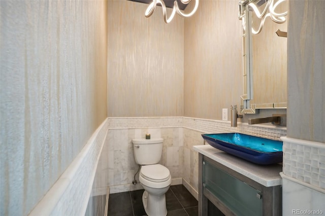 bathroom with vanity, toilet, tile walls, and tile patterned floors