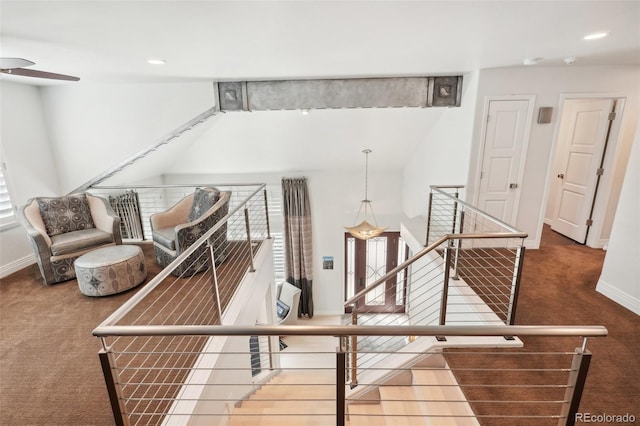 staircase with ceiling fan and carpet