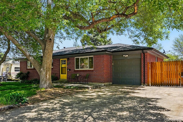 6088 Quail Ct, Arvada, CO 80004 - view of front of home featuring a garage, driveway, fence, and brick siding