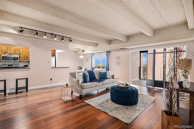 living room featuring beam ceiling, a textured ceiling, baseboards, and hardwood / wood-style flooring