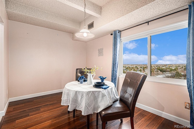 dining room with visible vents, a textured ceiling, baseboards, and wood finished floors