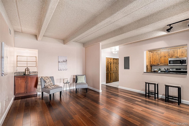 living area with baseboards, electric panel, dark wood-style flooring, a textured ceiling, and beamed ceiling