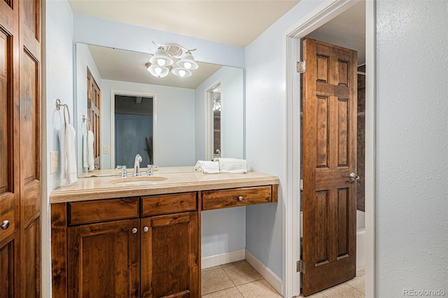 bathroom featuring tile patterned flooring, vanity, baseboards, and a tub to relax in