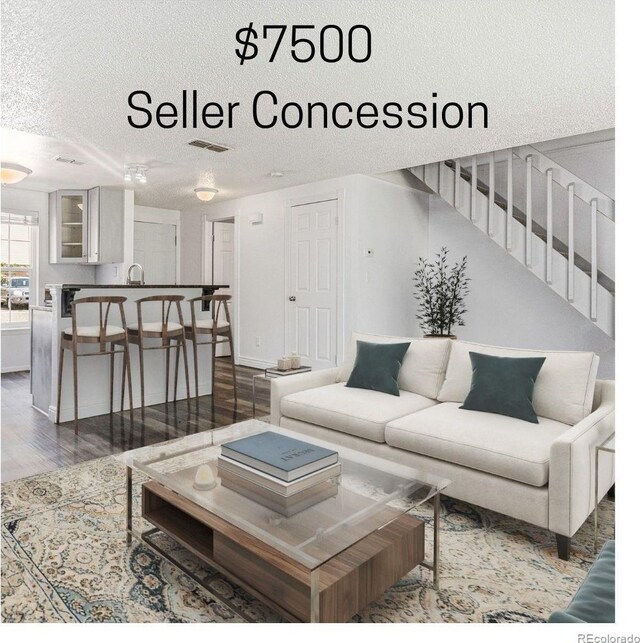 1534 S Ouray Cir Unit B, Aurora, CO 80017 - living room featuring a textured ceiling, wood finished floors, and stairs