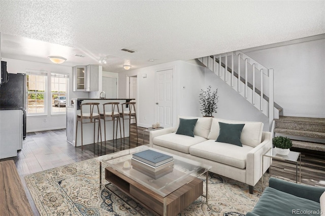 1534 S Ouray Cir Unit B, Aurora, CO 80017 - living area with a textured ceiling, stairway, wood finished floors, and baseboards