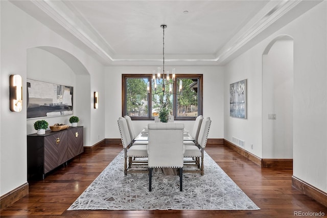 662 Yankakee Dr, Castle Rock, CO 80108 - dining space with arched walkways, a tray ceiling, visible vents, and dark wood-type flooring