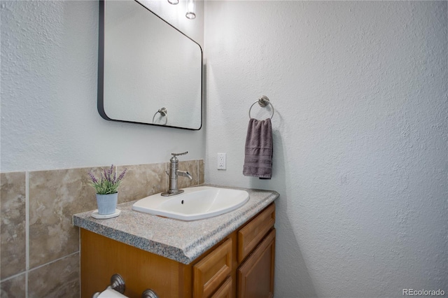 bathroom featuring a textured wall and vanity