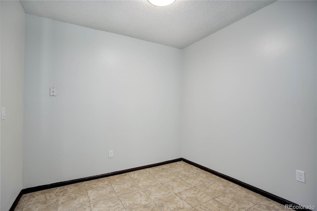 empty room featuring baseboards and a textured ceiling