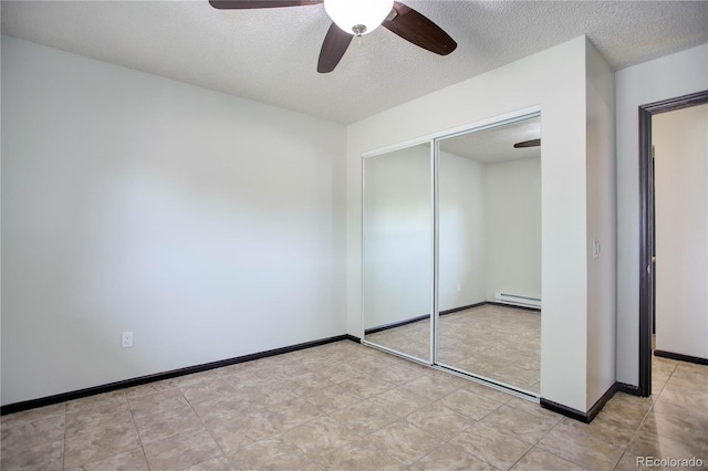 unfurnished bedroom with a baseboard heating unit, a closet, a textured ceiling, and baseboards