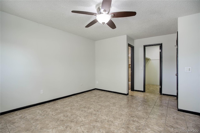 spare room featuring a textured ceiling and baseboards