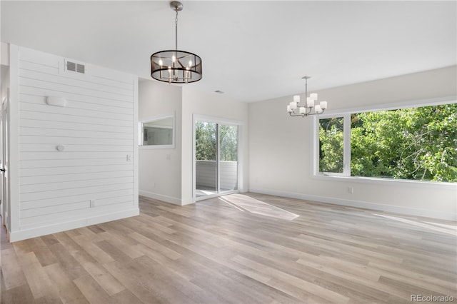 1308 Snowberry Ln Unit 303, Louisville, CO 80027 - unfurnished dining area featuring a chandelier, baseboards, and light wood-type flooring