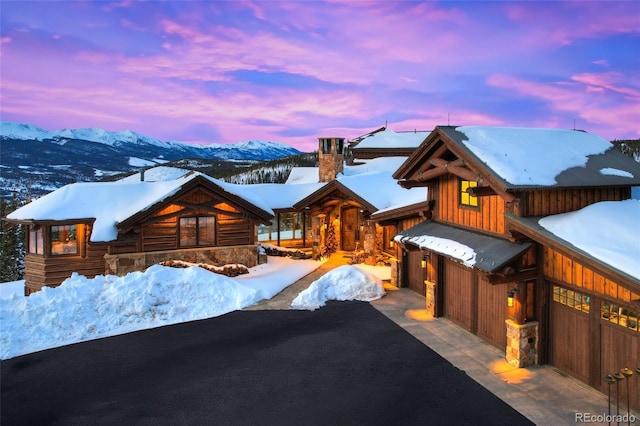 log home with a garage and a mountain view