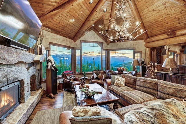 living room featuring hardwood / wood-style flooring, a mountain view, a stone fireplace, wooden ceiling, and beamed ceiling