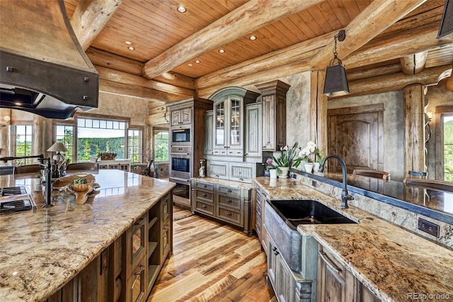 kitchen featuring rustic walls, beam ceiling, light wood-style flooring, and wood ceiling