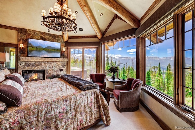 bedroom with multiple windows, access to exterior, a stone fireplace, and lofted ceiling with beams