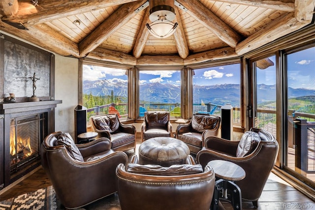 sunroom / solarium featuring a mountain view, vaulted ceiling with beams, and wooden ceiling