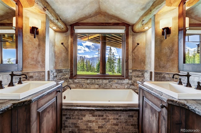 bathroom with vaulted ceiling, a relaxing tiled tub, and vanity