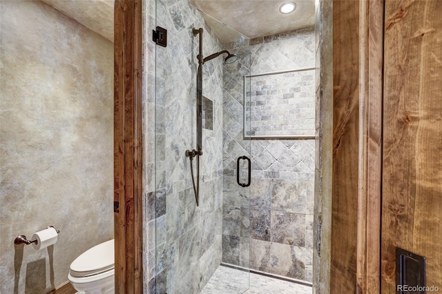 bathroom featuring toilet and an enclosed shower