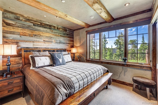 carpeted bedroom with multiple windows, beam ceiling, and wood walls