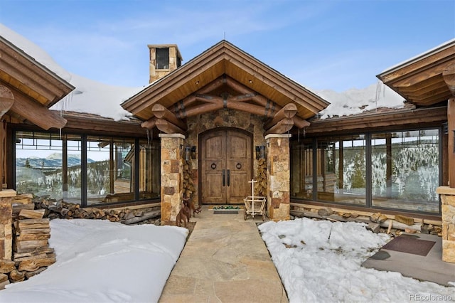 snow covered property entrance featuring a mountain view