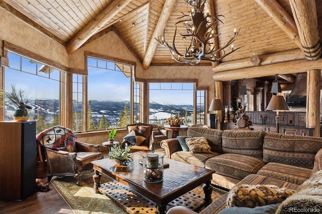 living area with high vaulted ceiling, hardwood / wood-style floors, rustic walls, an inviting chandelier, and wood ceiling