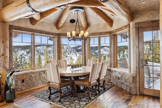 sunroom featuring an inviting chandelier, plenty of natural light, and vaulted ceiling with beams