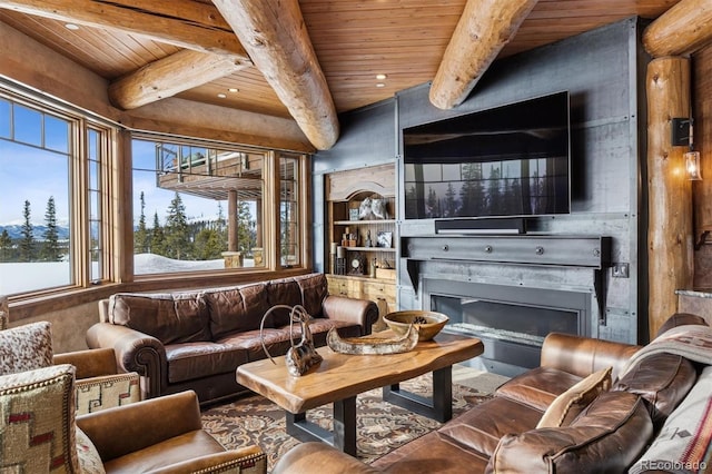 living area featuring beam ceiling, wood ceiling, and a glass covered fireplace