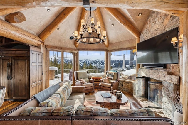 living area with beam ceiling, high vaulted ceiling, a notable chandelier, wood finished floors, and a fireplace