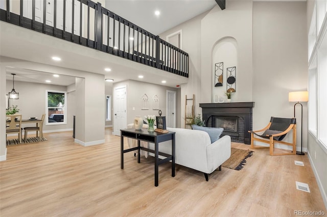 11260 W Fremont Ave, Littleton, CO 80127 - living area with a brick fireplace, a towering ceiling, light wood finished floors, and recessed lighting