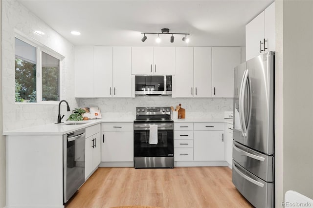 11260 W Fremont Ave, Littleton, CO 80127 - kitchen with stainless steel appliances, tasteful backsplash, light countertops, light wood-style floors, and white cabinets