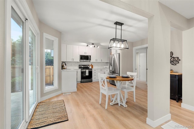 11260 W Fremont Ave, Littleton, CO 80127 - kitchen featuring appliances with stainless steel finishes, light wood-type flooring, light countertops, tasteful backsplash, and decorative light fixtures