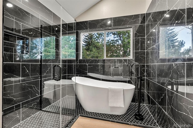 11260 W Fremont Ave, Littleton, CO 80127 - full bath featuring tile walls, a freestanding bath, a shower stall, and lofted ceiling