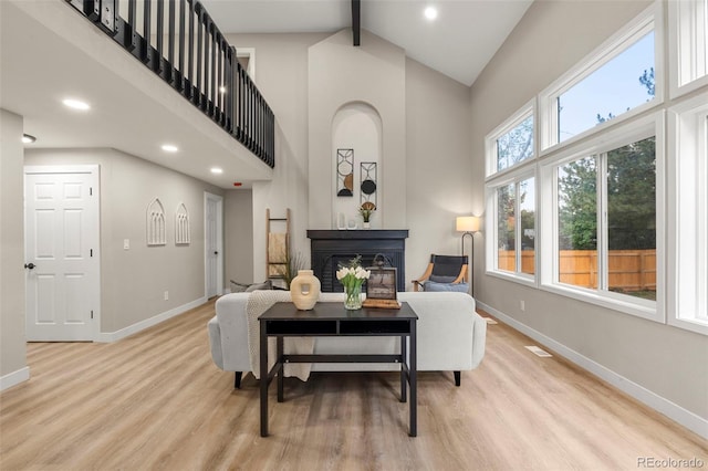 11260 W Fremont Ave, Littleton, CO 80127 - living area with high vaulted ceiling, a glass covered fireplace, light wood finished floors, beam ceiling, and recessed lighting