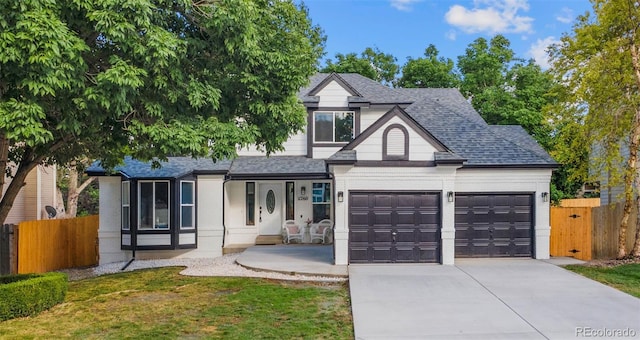 11260 W Fremont Ave, Littleton, CO 80127 - view of front of home with an attached garage, concrete driveway, a shingled roof, a porch, and brick siding