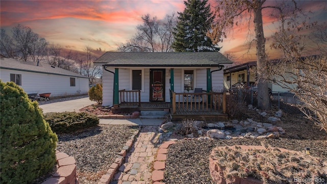 view of front of property with covered porch, driveway, and roof with shingles