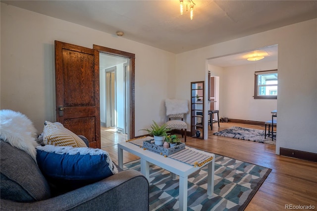 living area featuring baseboards and light wood-style floors