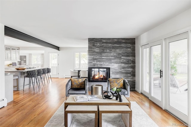 3901 S Dexter St, Cherry Hills Village, CO 80113 - living area with an accent wall, light wood-type flooring, a multi sided fireplace, and baseboard heating