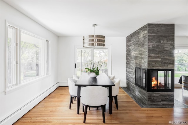 3901 S Dexter St, Cherry Hills Village, CO 80113 - dining room featuring a baseboard heating unit, wood finished floors, and a multi sided fireplace