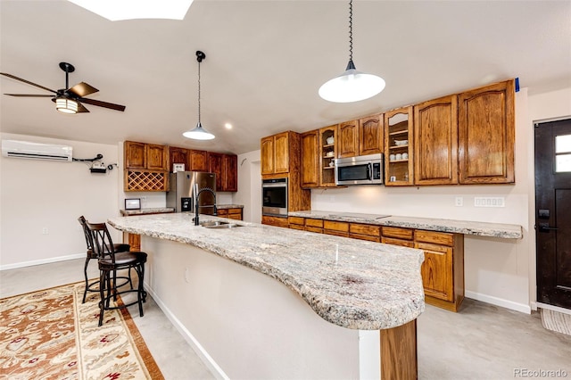 24130 High Timber Ln, Agate, CO 80101 - kitchen with stainless steel appliances, a sink, a wall unit AC, brown cabinetry, and baseboards