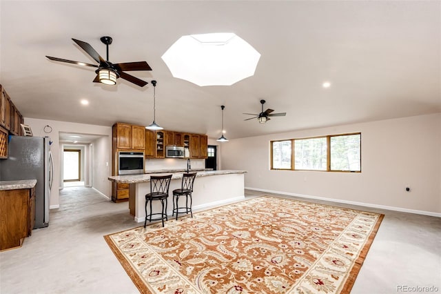 24130 High Timber Ln, Agate, CO 80101 - kitchen featuring stainless steel appliances, a ceiling fan, brown cabinets, lofted ceiling, and baseboards