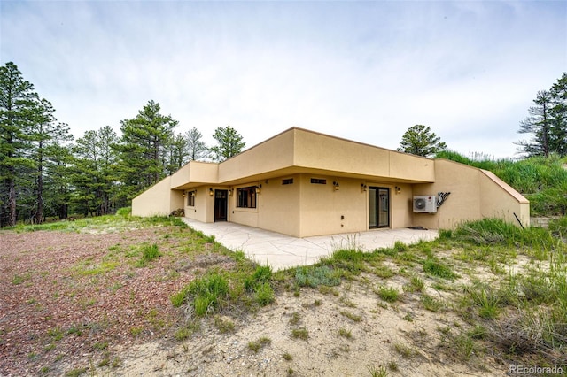 24130 High Timber Ln, Agate, CO 80101 - back of property with stucco siding, ac unit, and a patio area