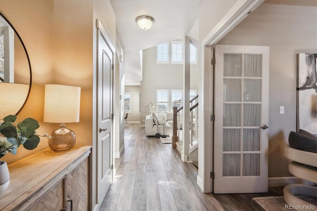 hall with hardwood / wood-style floors and vaulted ceiling